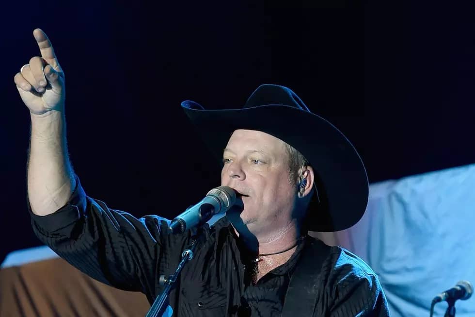 a man in a cowboy hat singing into a microphone